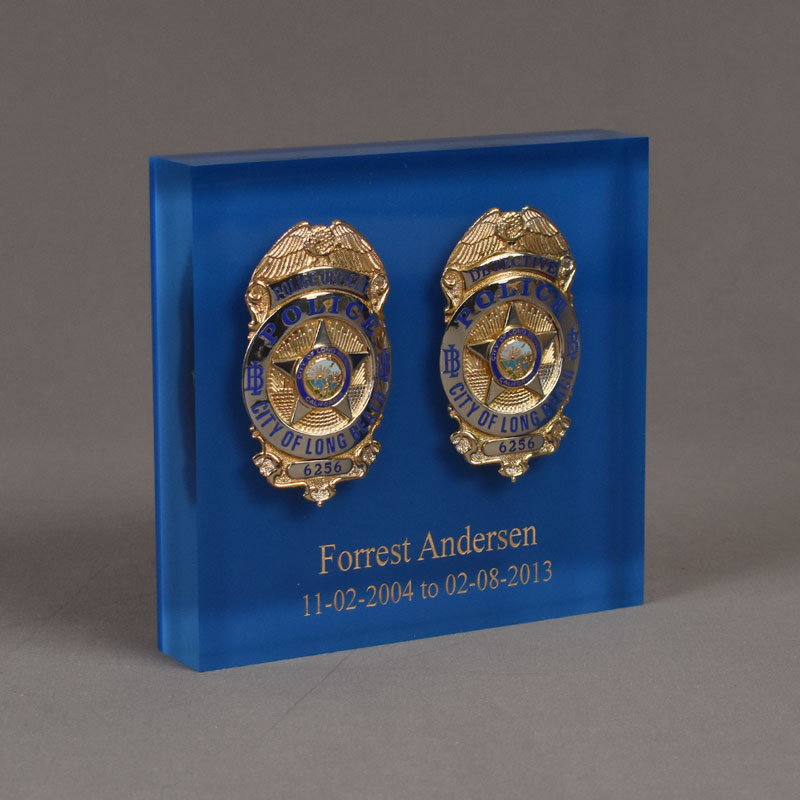 Two police badges with blue accented acrylic background to highlight the gold service badges.